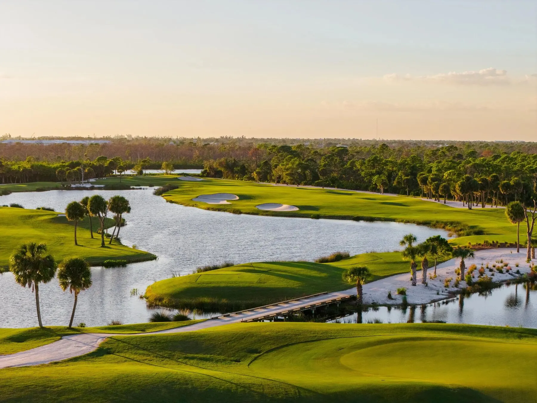Palm-lined lake and bridge at Coral Creek Club