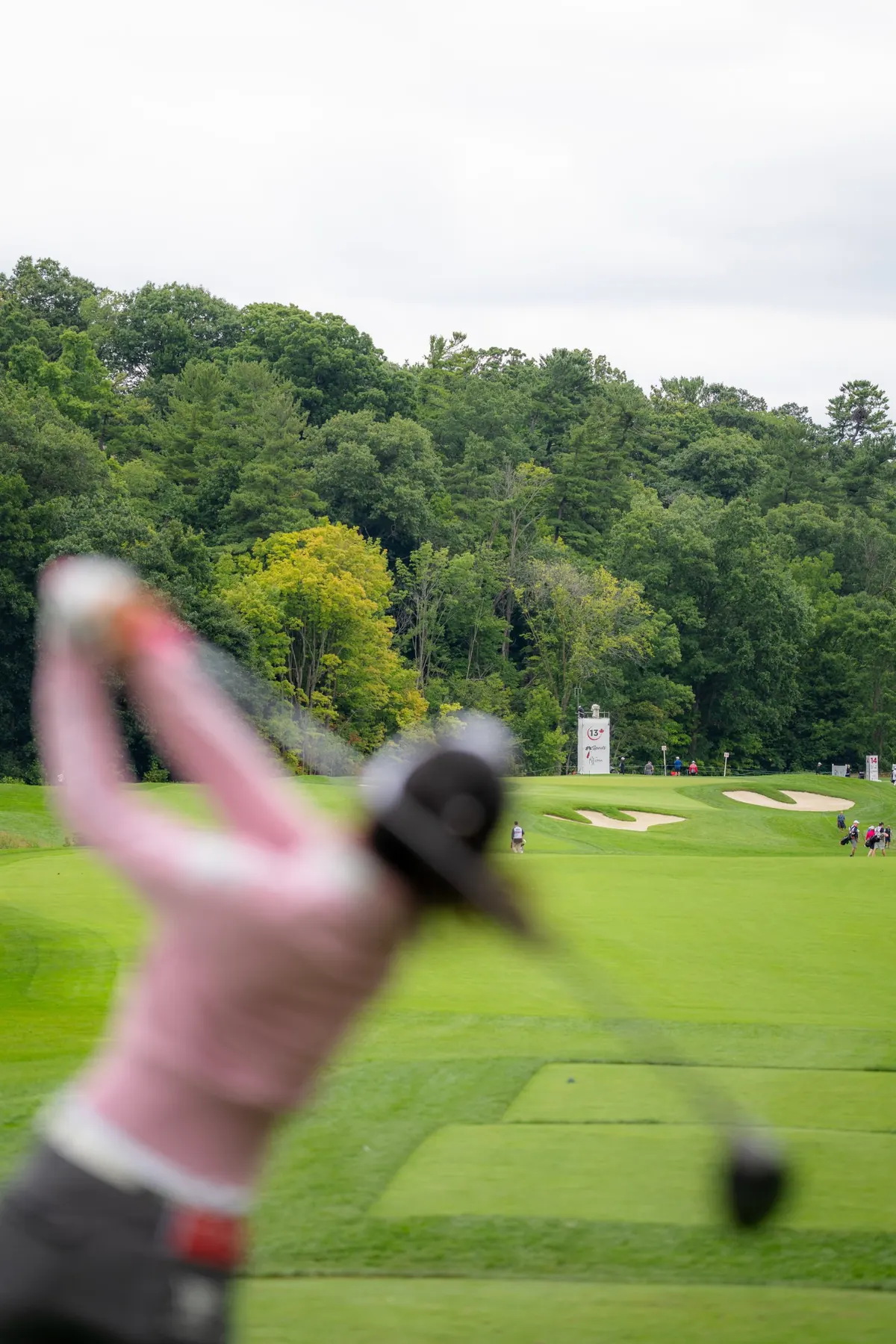 A blurred swing in the foreground with the 13th green beyond